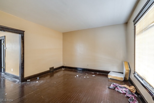 unfurnished room featuring plenty of natural light and dark hardwood / wood-style floors