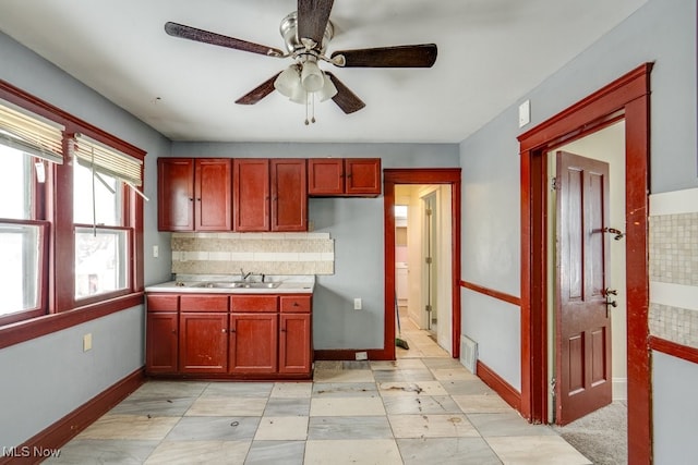 kitchen featuring backsplash, sink, ceiling fan, and refrigerator