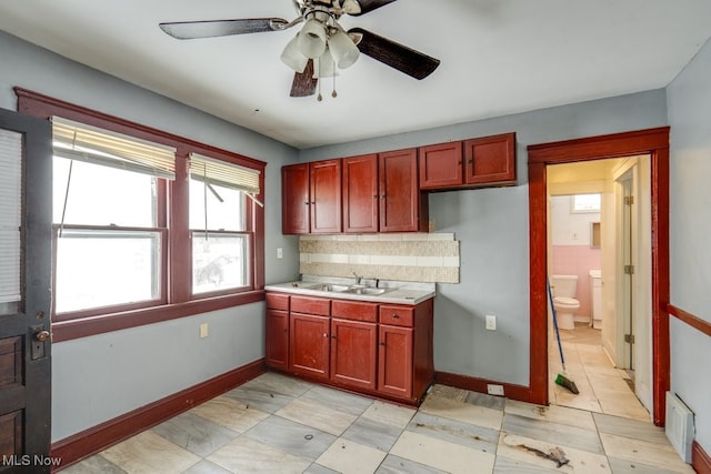 kitchen featuring sink, backsplash, and ceiling fan