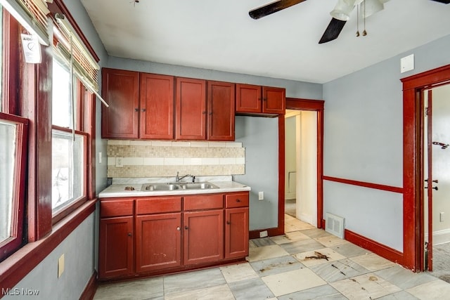 kitchen with ceiling fan, sink, and backsplash