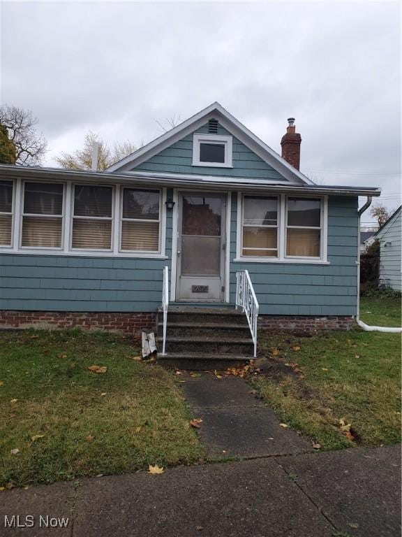 bungalow-style home featuring a front yard