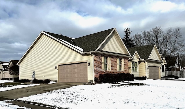 snow covered property with a garage