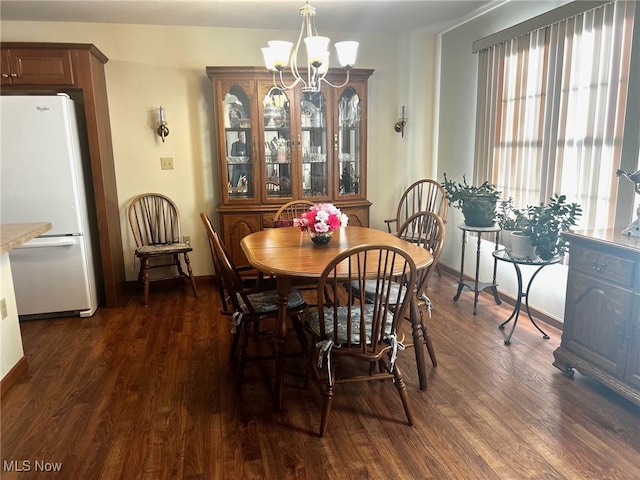 dining room with dark wood-type flooring and a chandelier