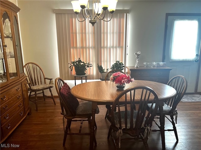 dining area with dark wood-type flooring and a chandelier