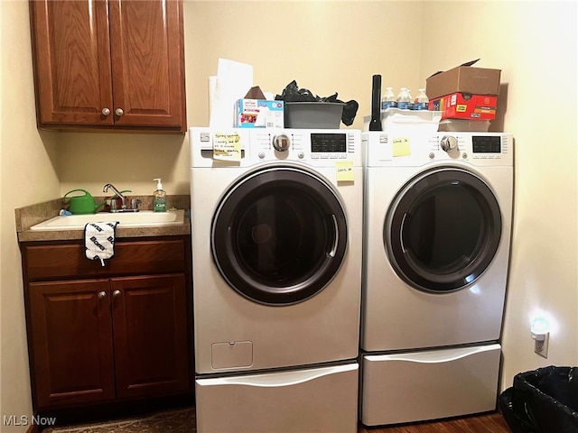 laundry area featuring cabinets, independent washer and dryer, and sink