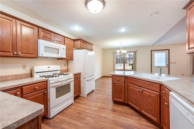 1089 Park Pl, Niles, OH 44446 - kitchen with sink, decorative light fixtures, a chandelier, light hardwood / wood-style flooring, and white appliances