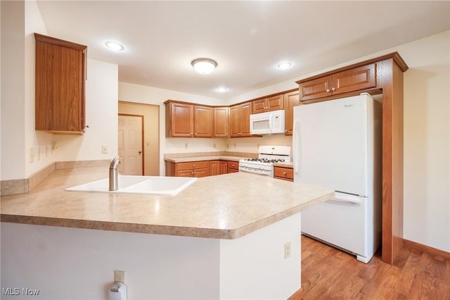 1089 Park Pl, Niles, OH 44446 - kitchen with light hardwood / wood-style floors, sink, white appliances, and kitchen peninsula