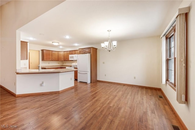 1089 Park Pl, Niles, OH 44446 - kitchen featuring pendant lighting, white appliances, kitchen peninsula, and light wood-type flooring
