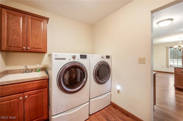 1089 Park Pl, Niles, OH 44446 - washroom featuring washing machine and clothes dryer, sink, an inviting chandelier, cabinets, and light wood-type flooring