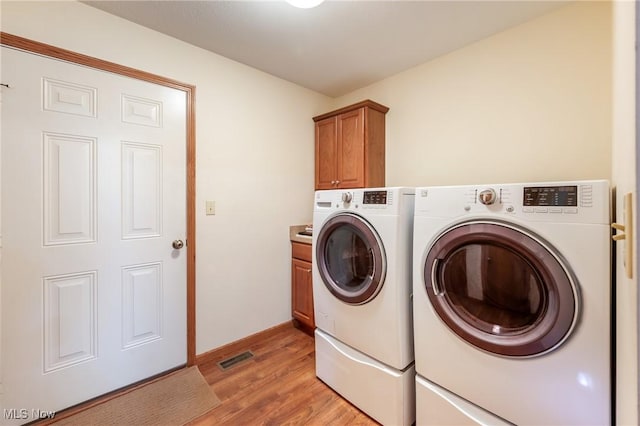 1089 Park Pl, Niles, OH 44446 - laundry area with cabinets, washing machine and clothes dryer, and light hardwood / wood-style flooring