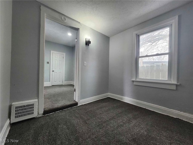 unfurnished room with a textured ceiling