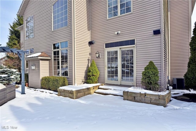 snow covered property entrance with central AC