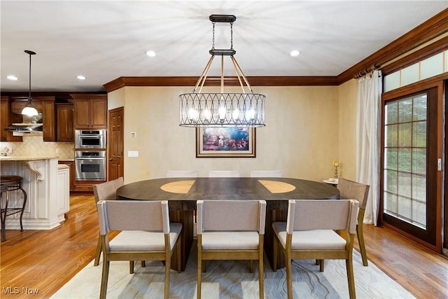 dining area with ornamental molding and light wood-type flooring