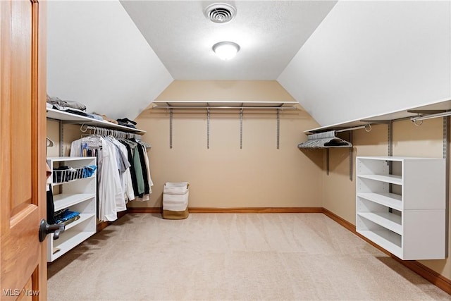 spacious closet with lofted ceiling and carpet floors