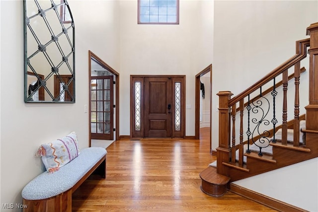 foyer entrance featuring hardwood / wood-style flooring and a towering ceiling