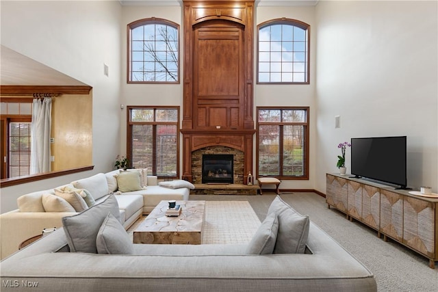 carpeted living room with a high ceiling and a fireplace