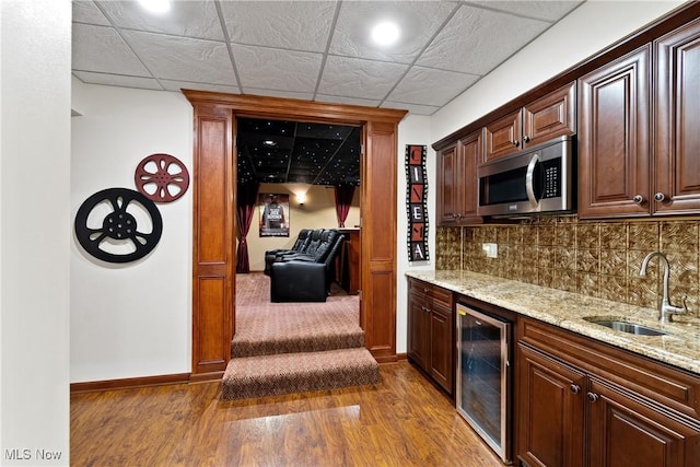 bar featuring light stone countertops, sink, a drop ceiling, and wine cooler