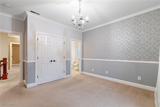 unfurnished bedroom with light colored carpet, ornamental molding, a chandelier, and a closet