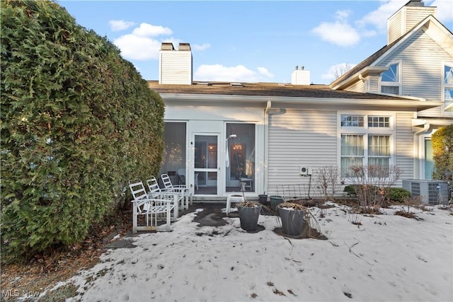 snow covered property featuring central AC