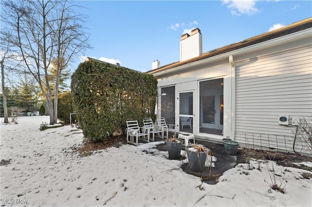 snow covered house with a sunroom