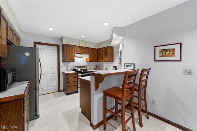 kitchen featuring stainless steel appliances, a kitchen breakfast bar, and kitchen peninsula