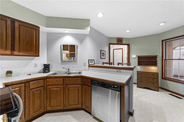 kitchen with stainless steel dishwasher, kitchen peninsula, sink, and stove