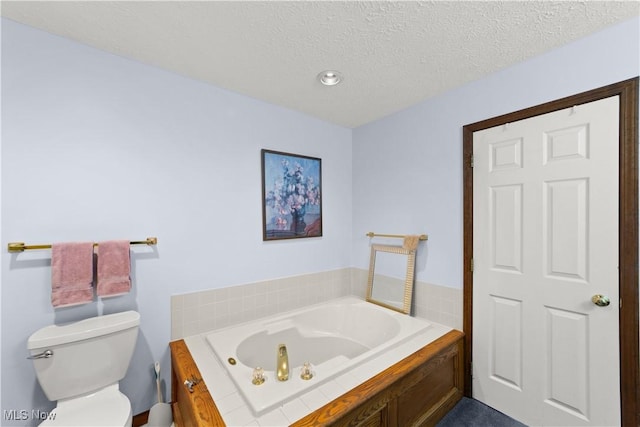 bathroom with a tub, a textured ceiling, and toilet