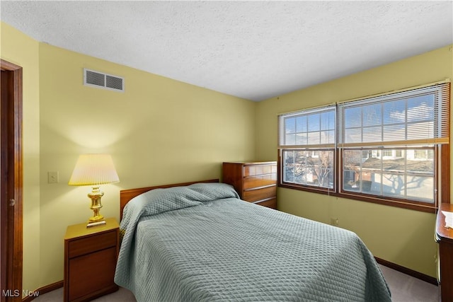 bedroom with a textured ceiling and carpet