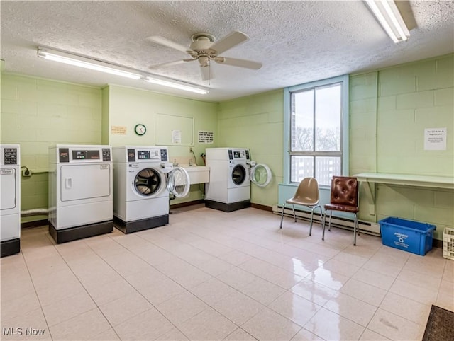 clothes washing area featuring ceiling fan, a baseboard radiator, washing machine and dryer, and a textured ceiling