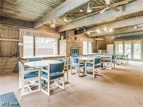 dining room featuring beamed ceiling, ceiling fan, and carpet flooring