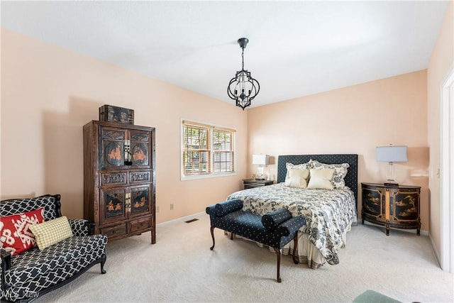 carpeted bedroom featuring an inviting chandelier