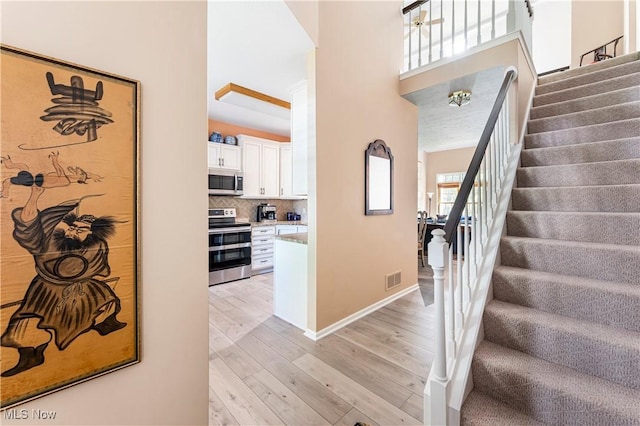 entryway with light hardwood / wood-style flooring and a high ceiling