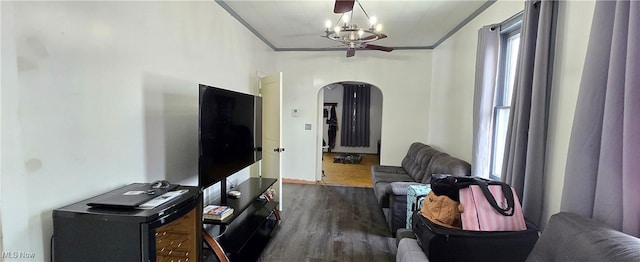 living room featuring a notable chandelier, dark wood-type flooring, and ornamental molding