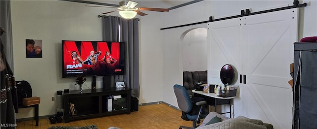 office area with hardwood / wood-style flooring, a barn door, and ceiling fan