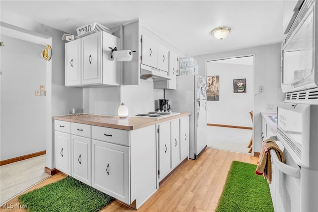 kitchen with white cabinetry, white appliances, and light wood-type flooring