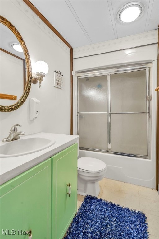 full bathroom featuring tile patterned flooring, bath / shower combo with glass door, vanity, and toilet