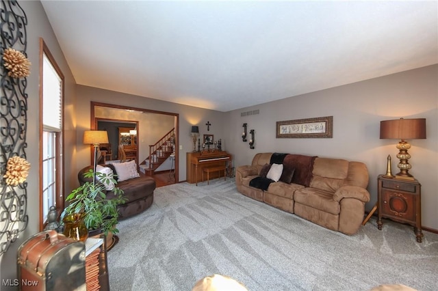 carpeted living area with visible vents and stairway