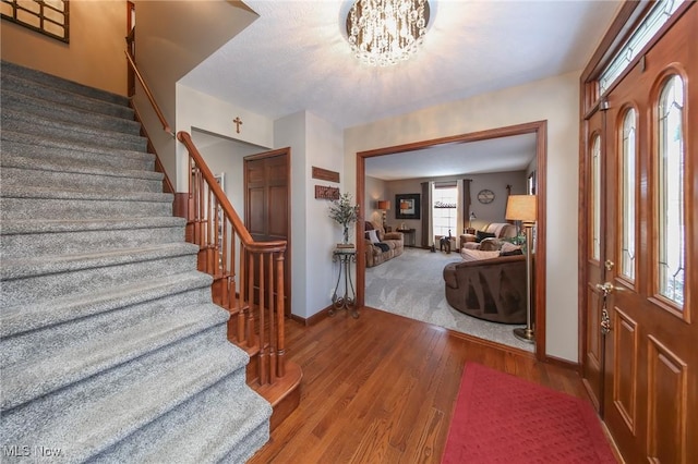 foyer with wood-type flooring and a chandelier