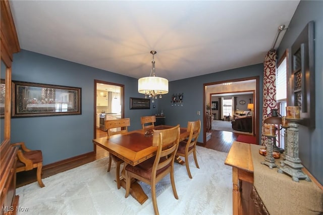 dining space with light wood-style floors and baseboards