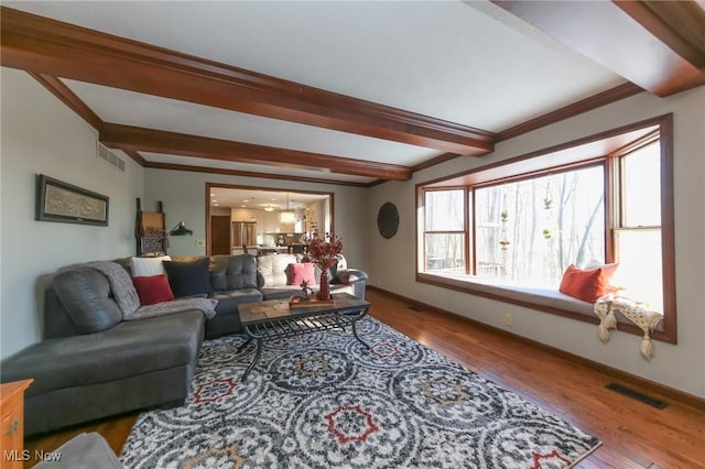 living room with beamed ceiling and light hardwood / wood-style flooring