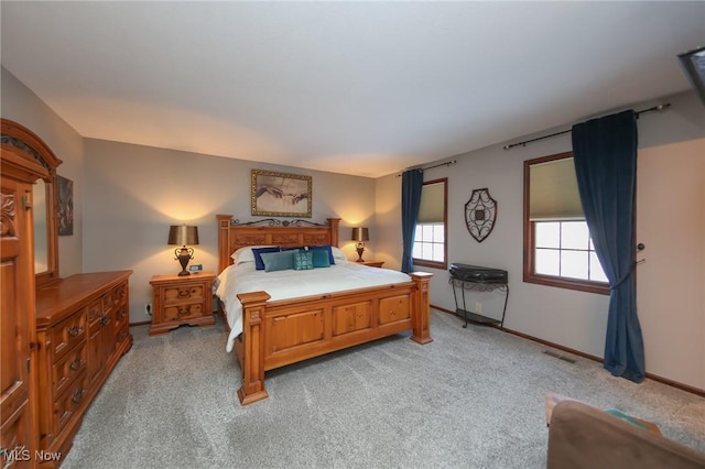 bedroom featuring baseboards, visible vents, and light carpet