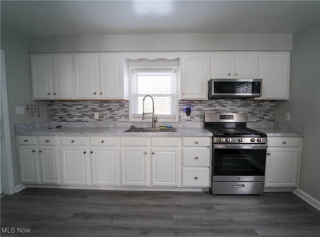 kitchen featuring white cabinetry, appliances with stainless steel finishes, dark hardwood / wood-style floors, and sink