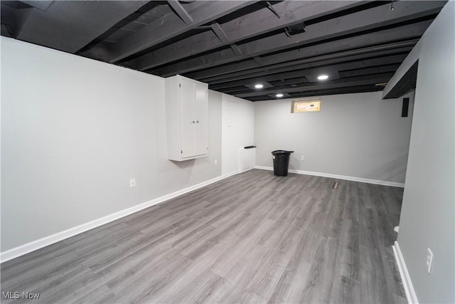 basement with light hardwood / wood-style flooring