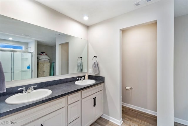 bathroom with vanity, hardwood / wood-style floors, a shower with door, and toilet