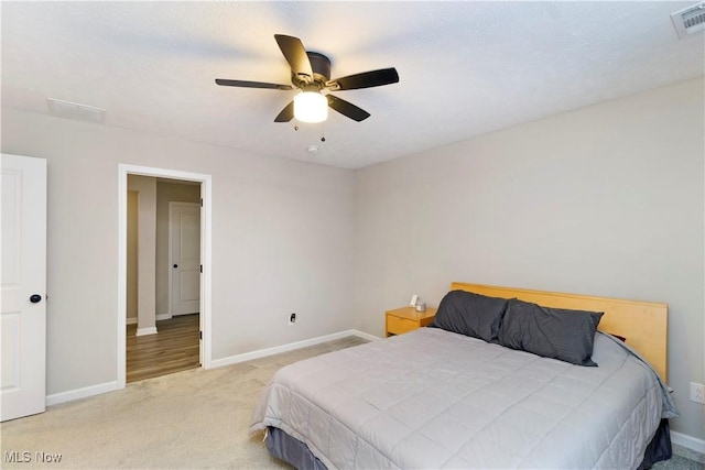 bedroom with ceiling fan and light colored carpet