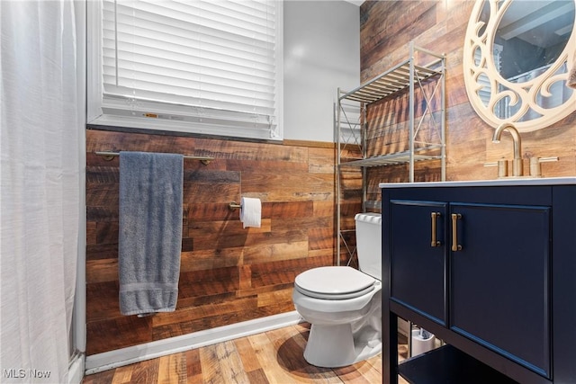 bathroom with vanity, hardwood / wood-style floors, toilet, and wood walls