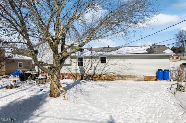 view of snow covered back of property