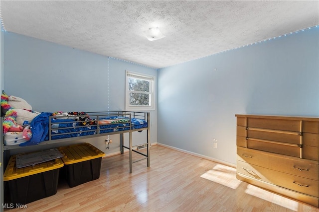 bedroom with hardwood / wood-style flooring and a textured ceiling