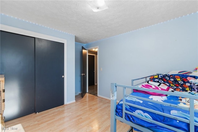 bedroom featuring hardwood / wood-style floors, a closet, and a textured ceiling