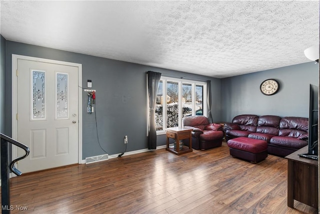 living room featuring dark hardwood / wood-style floors and a textured ceiling